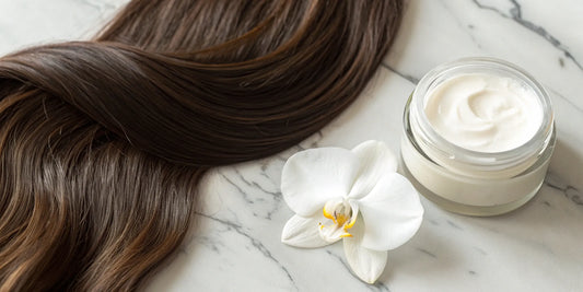 Hydrating finishing cream jar with orchid on marble.