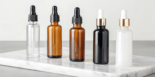 Hair serums for frizz control arranged on a marble surface.